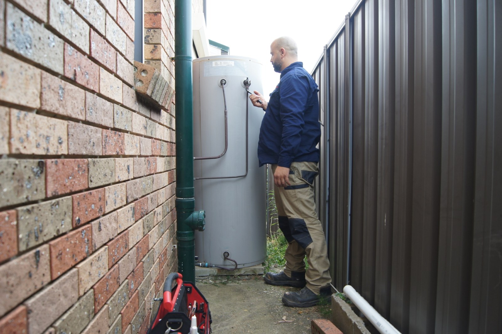 Fixed Today plumber at a hot water system beside a Sydney home
