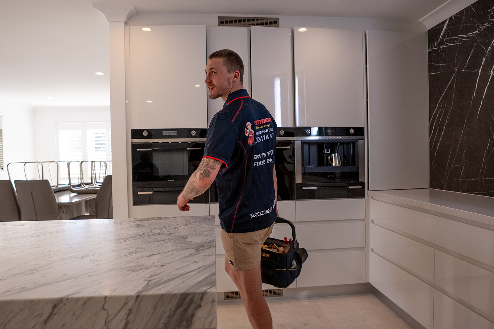 Fixed Today plumber with his tool bag in a Sydney kitchen
